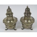 A pair of HM silver pepperettes of baluster form raised over three outswept feet,