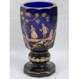 A fine cobalt blue and gilded faceted glass goblet decorated with figures upon, 17cm high.