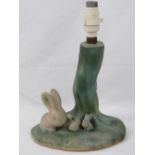 A c1950s ceramic child's table lamp base decorated with rabbits upon.