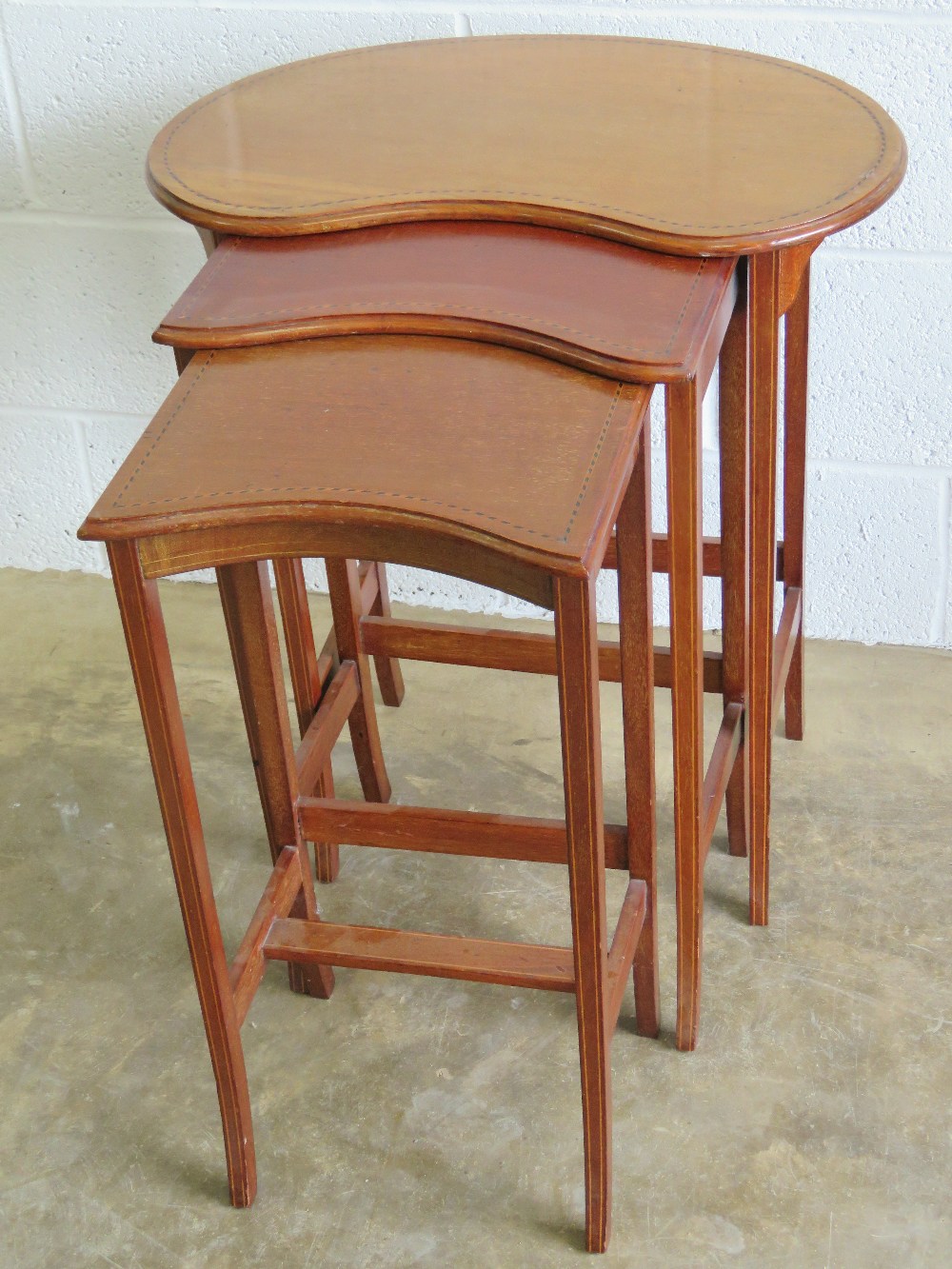 A smart Edwardian nest of three mahogany tables, graduating from 59cm, 38cm and 32cm width.