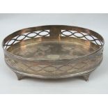 A white metal oval tray with pierced gallery and raised over four feet,