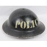 A WWII British Police Officers helmet in original black paint with Police insignia upon, dated 1939,