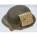 A WWII British Military 'Tommy' helmet with camo netting and emergency first aid field dressing