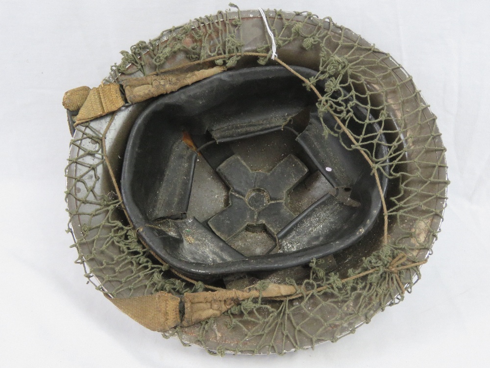 A WWII British Military 'Tommy' helmet with camo netting and emergency first aid field dressing - Image 2 of 3