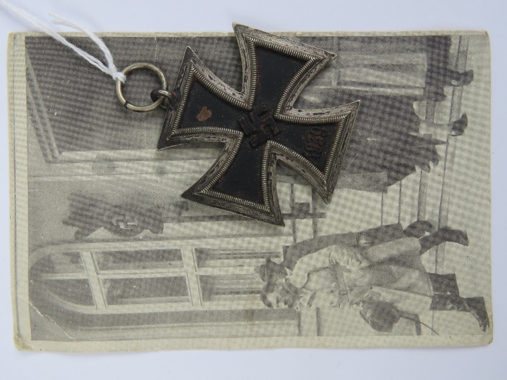 A WWII German Iron Cross medal, together with a photo postcard of Hitler. Two items.