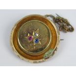 A delightful Edwardian yellow metal brooch of circular form having central flower set with pink,