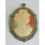 A cameo brooch / pendant having carved shell female portrait surrounded by turquoise cabachons and