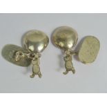 A pair of silver cufflinks in the form of Winnie the Pooh dangling from a balloon,