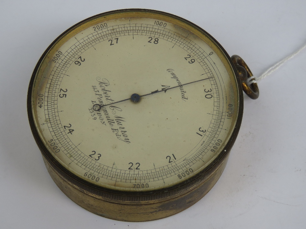 A brass cased Victorian compensated pocket barometer having broad arrow upon,