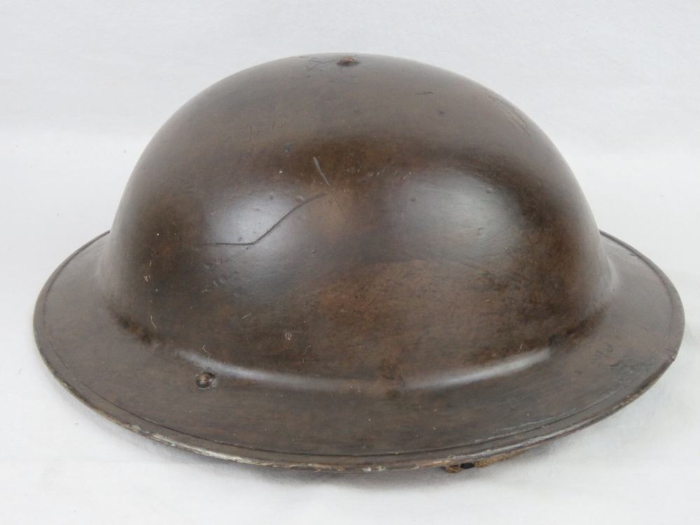 A WWII Brodie Mk1 helmet in BEF colours c1940, with liner and chin strap.