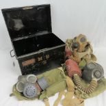 Three British Military gas masks in bags, together with a WWII Officers foot locker case.