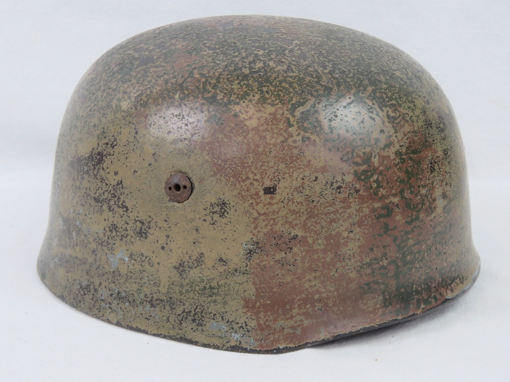 A reproduction WWII German Paratrooper Fallshirmjager helmet with liner and chin strap.