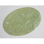 A pierced oval green jade Oriental disc,