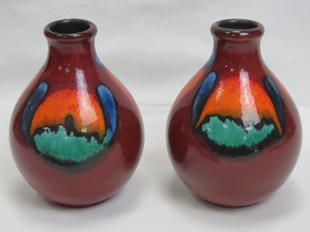 A pair of Poole Pottery red ground short