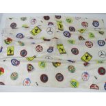 A silk racing scarf embellished with the manufacturers badges for Ferrari, MG, Lotus, Porsche,