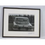 A hand signed black and white photograph of Paddy Hopkirk in his Triumph 2000 VBL195H,