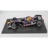 A 1:18 scale Red Bull racing F1 car signed by David Coulthard, 25.5cm in length on base.