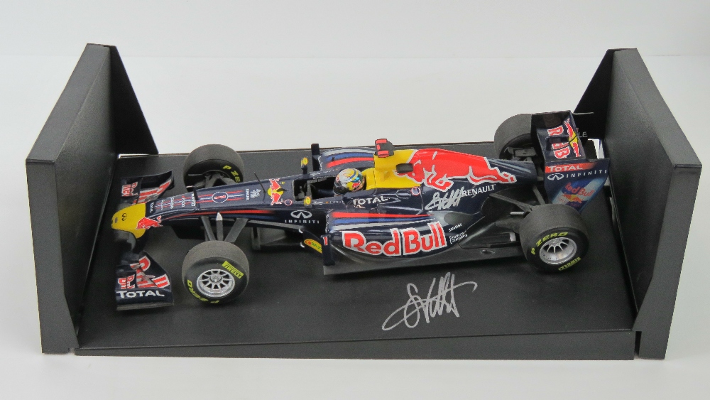 A 1:18 scale Red Bull racing F1 car signed by Sebastian Vettel 2001 25.5cm in length on base.