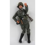 A scale model Action Man type doll in full WWII German soldier dress complete with stick grenade,