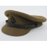 A green chaplain or padres peaked cap complete with badge as made by Moss Bros of Covent Garden,