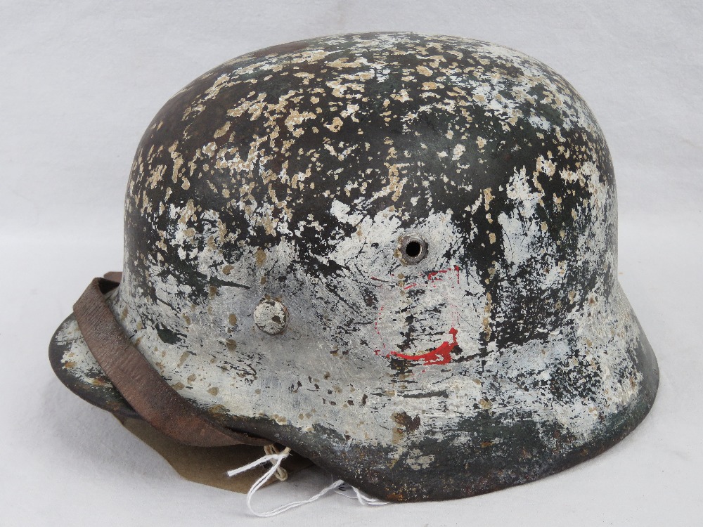 A German M35 SS helmet having two decals upon, in worn condition,