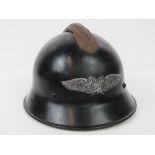 A WWII German Luftschutz Home Guard helmet with decal, liner, chin strap and raised over crest.