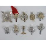 Ten assorted badges including; East Anglia Regiment, Home Counties, etc.