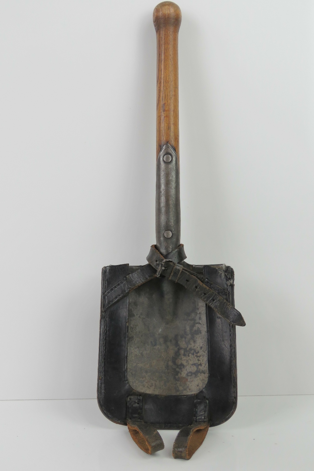 A WWII German Wehrmacht Infantry issue trenching tool with leather carrier and makers mark upon.