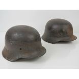 Two WWII German Infantry helmets being battlefield finds with no liners.