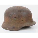 A WWII German helmet with remnants of liner and original chin strap.