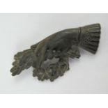 A carved ebony brooch in the form of a hand and floral arrangement,