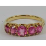 A five stone pink sapphire ring (treated stones), the graduated stones weighing approx 1.