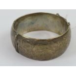 A Sterling silver wide cuff bangle having floral engraving to front, approx 6cm internal dia.