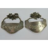 A pair of Sterling silver decanter labels being 'Whisky' and 'Cognac', each marked stirling.