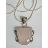 A silver and rose quartz pendant of square form and measuring 4cm in length,