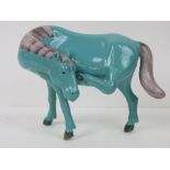 An oriental turquoise blue horse standin