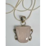 A silver and rose quartz pendant of squa