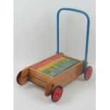 A vintage Tri-Ang wheeled baby-walker co