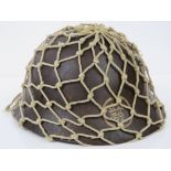 A WWII Japanese Military Infantry issue helmet with scrim netting and regimental painted crest.