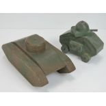 Two vintage handmade wooden toy tanks, one painted in camo with rotating turret and wheels,