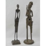 Two cast metal stylised African figurines, each standing around 29cm high.