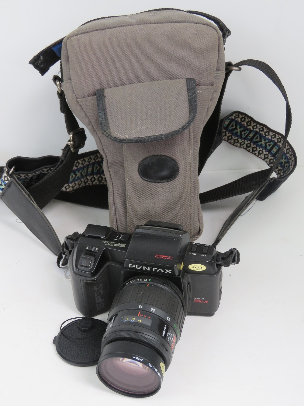 A Pentax SFX 35mm SLR camera with 35-135mm 1:3.5-4.5 lense, with padded carry case and strap.