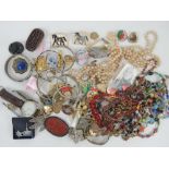 A quantity of assorted costume jewellery including Chinese carved red resin brooch, badges, bangles,