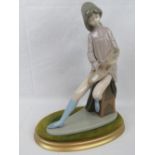 A Nao figurine of a seated girl with artists board and paintbrush (brush has come loose), 35cm high.