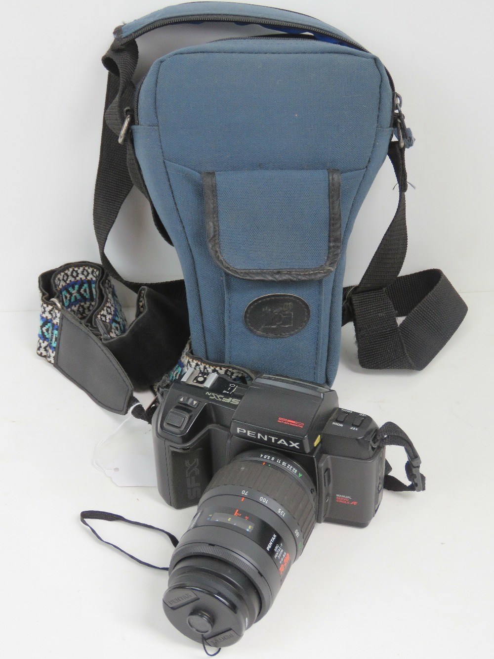 A Pentax SFX 35mm SLR camera having 70-210mm 1:4-5.6 Pentax lense, with padded carry case.