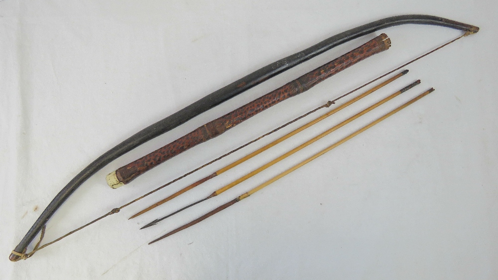 An ethnic tribal wood self bow with gut string and carved nocks,