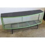 A large glazed metal framed display case, bow fronted, with light over, complete with stand,