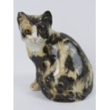A seated tortoiseshell Winstanley pottery cat with glass eyes, 22cm high, slight chip to ear.