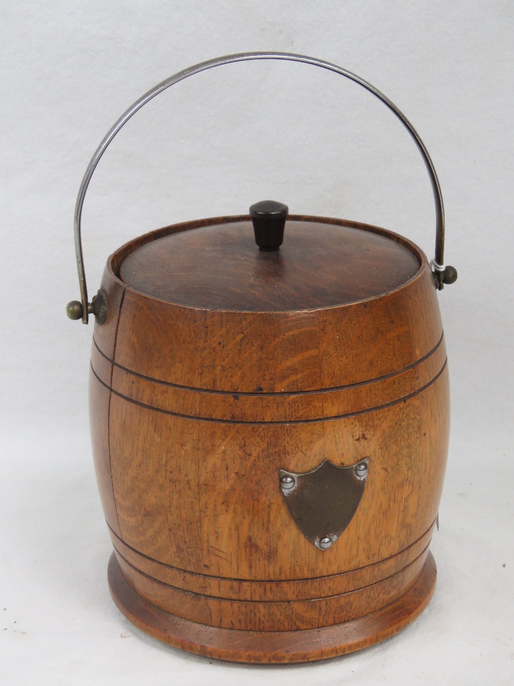 A c1930s oak ice bucket with swing handle and lid.