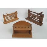 Two vintage wooden pipe racks in the form of gates, together with another pipe rack. Three items.